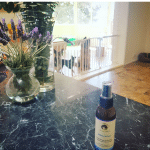 stillness and calm bottle on bench with lavender and dogs in background at Canine Culture Australia